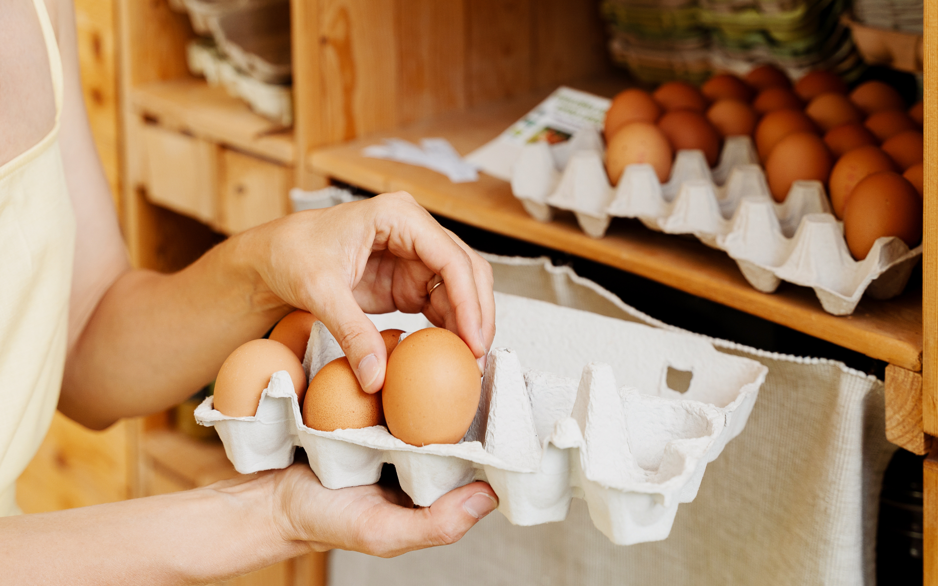 Person selects brown eggs from a carton, representing food cravings for eggs.