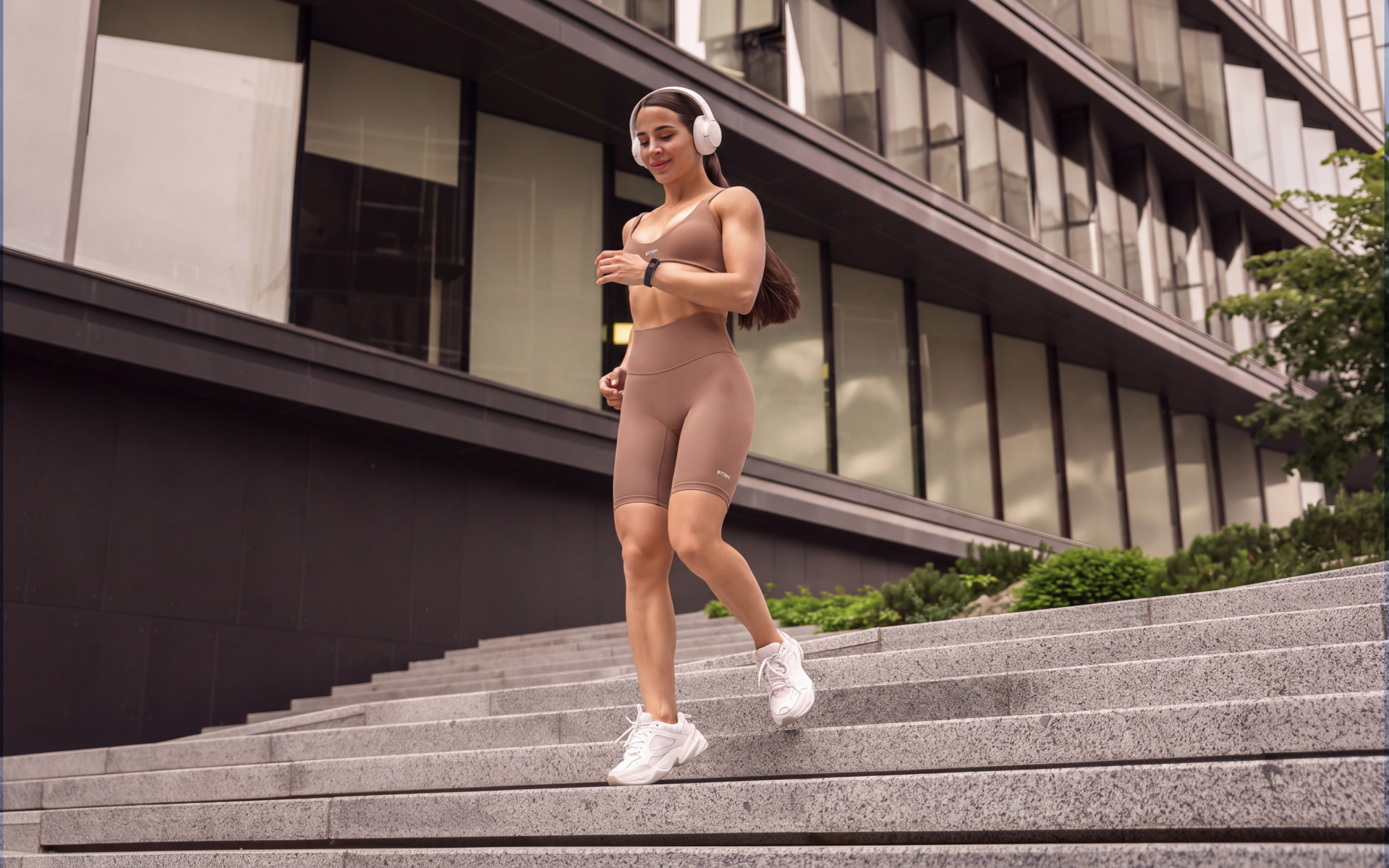Woman walking down outdoor steps while wearing headphones for different types of walking styles.