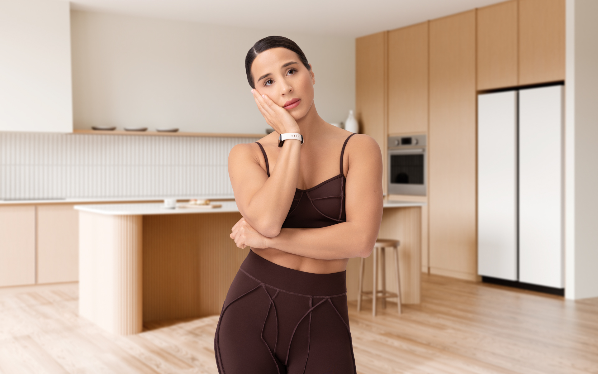 Thoughtful woman standing in a modern kitchen, illustrating common intermittent fasting mistakes and the importance of a balanced approach.