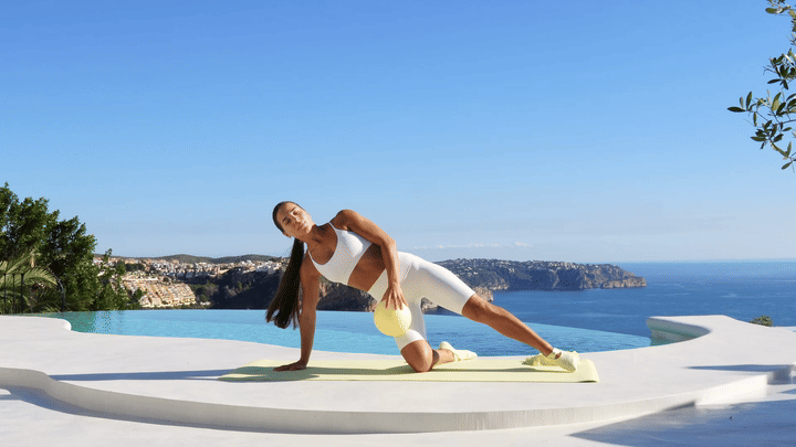 Lessie Fitness performing banded arm + leg raises (left side)