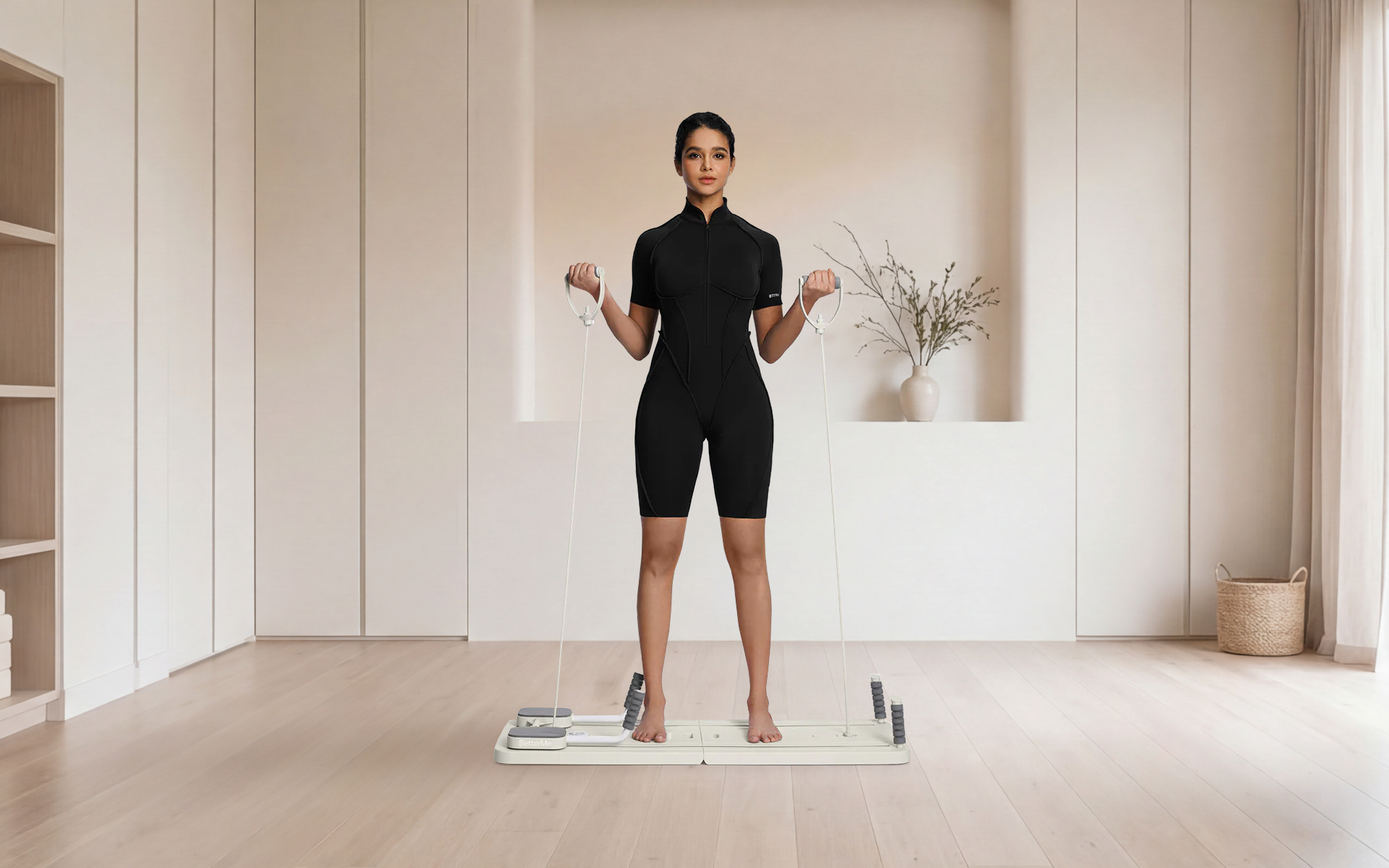 Woman demonstrating a pilates reformer flow sequence in a bright studio, standing on a compact reformer machine with handles in both hands.