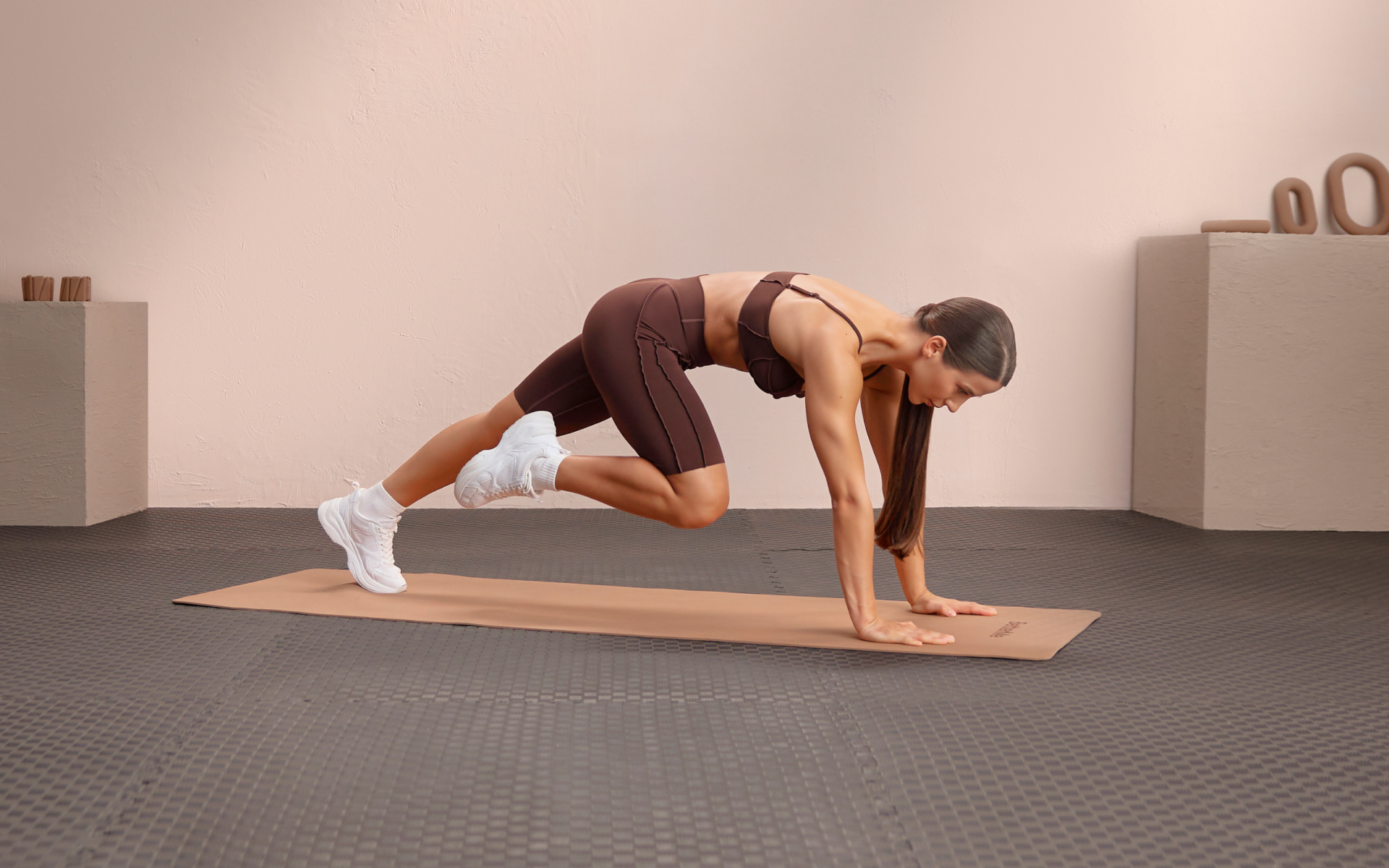 Woman performing mountain climbers on a mat, demonstrating calisthenics workouts at home for beginners without equipment.