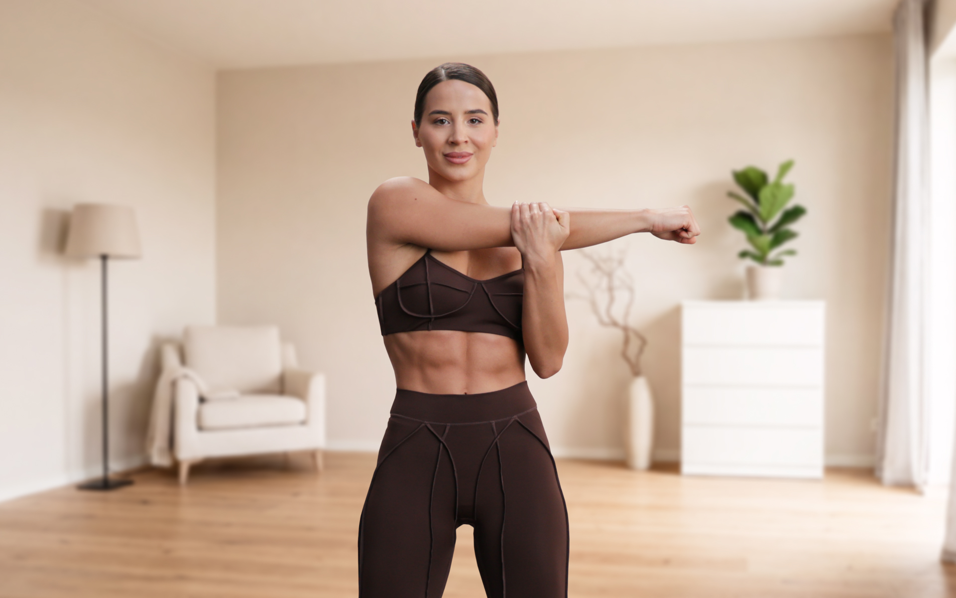 Woman stretching her arm in activewear, demonstrating arm toning exercises for females in a simple home workout.