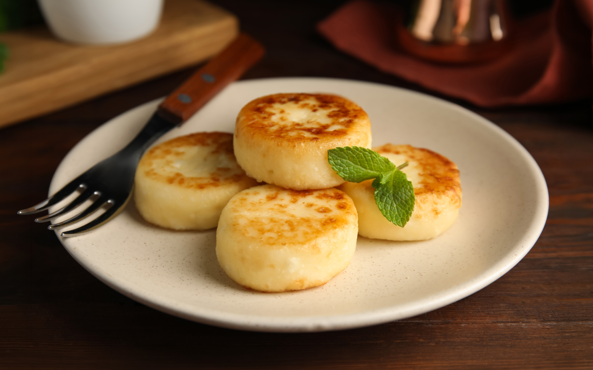 Pan-fried cheese cakes on a plate with mint garnish, offering high protein lunch ideas easy to prepare at home.
