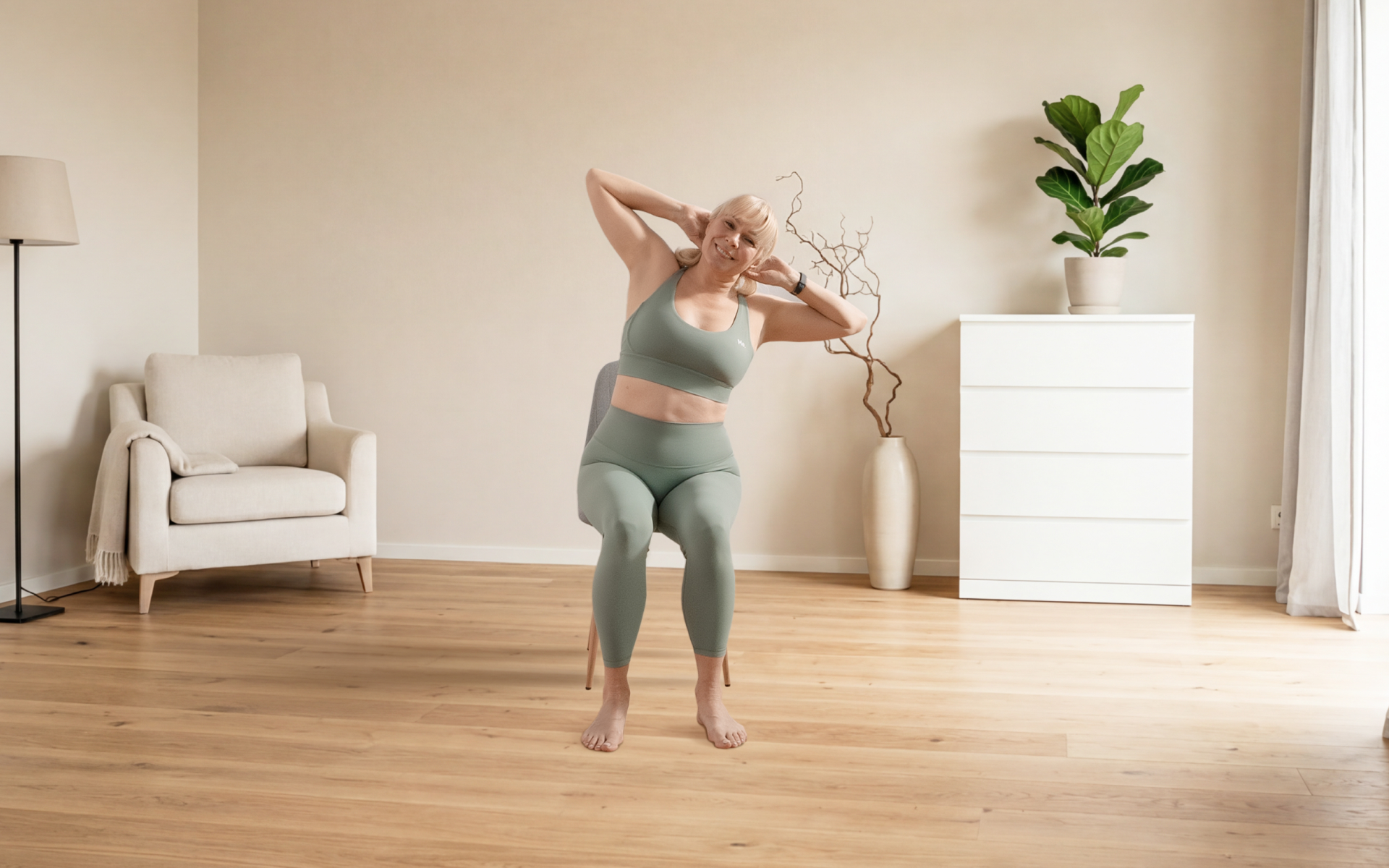 Woman over 50 practicing chair yoga for beginners over 50 with a seated side stretch in a bright home living room.