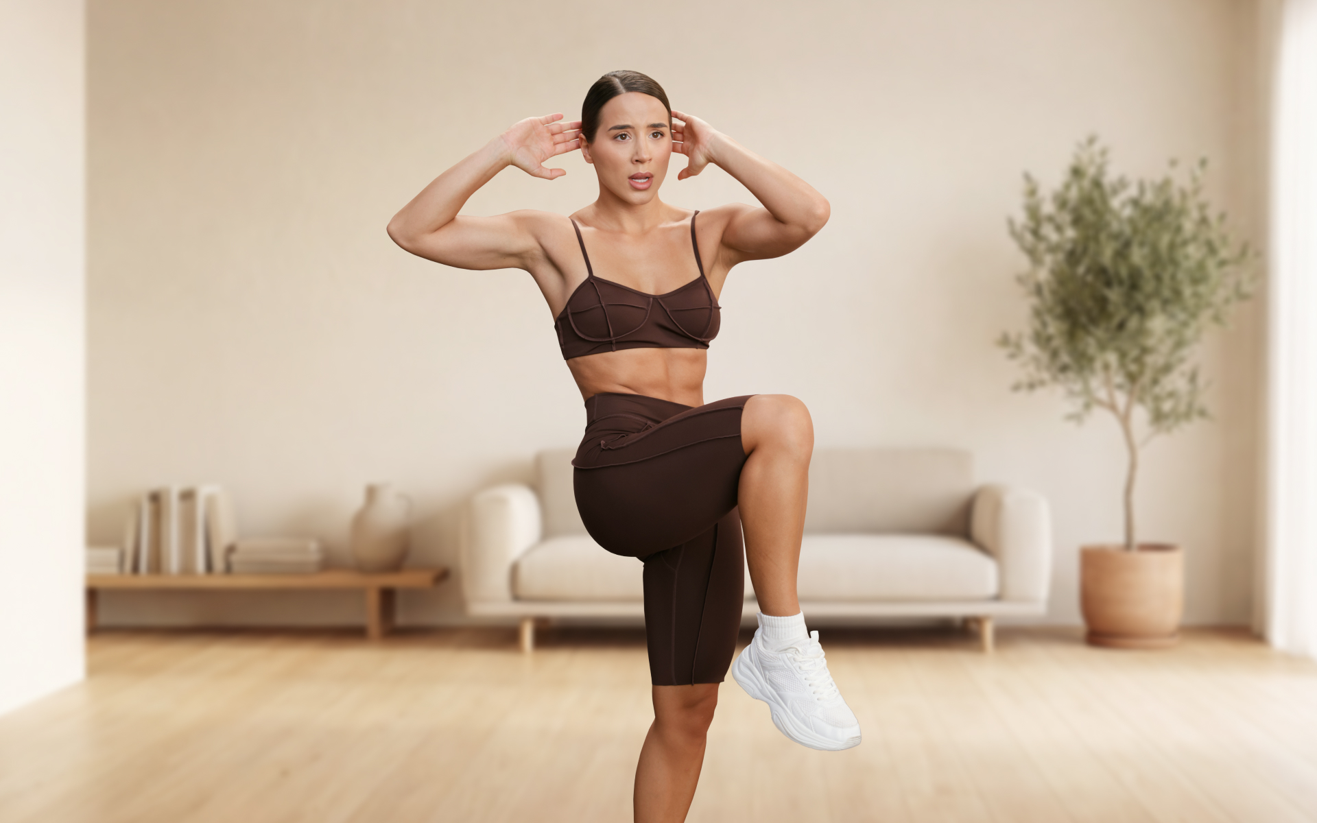 Woman performing standing ab workouts by lifting one knee toward her torso while engaging her core in a home workout space.