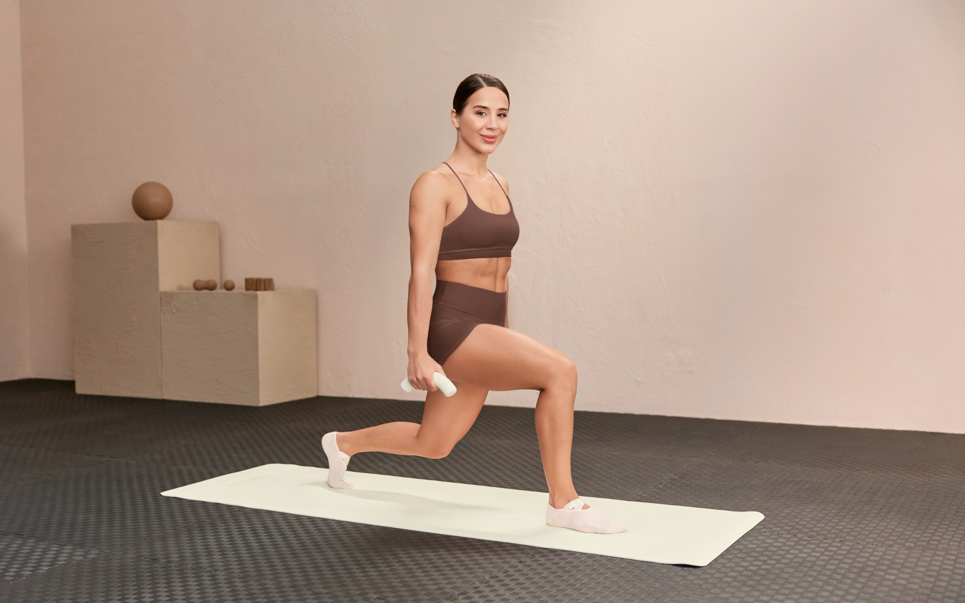 Woman performing a lunge with dumbbells during a superset leg workout designed to build lower-body strength and endurance.
