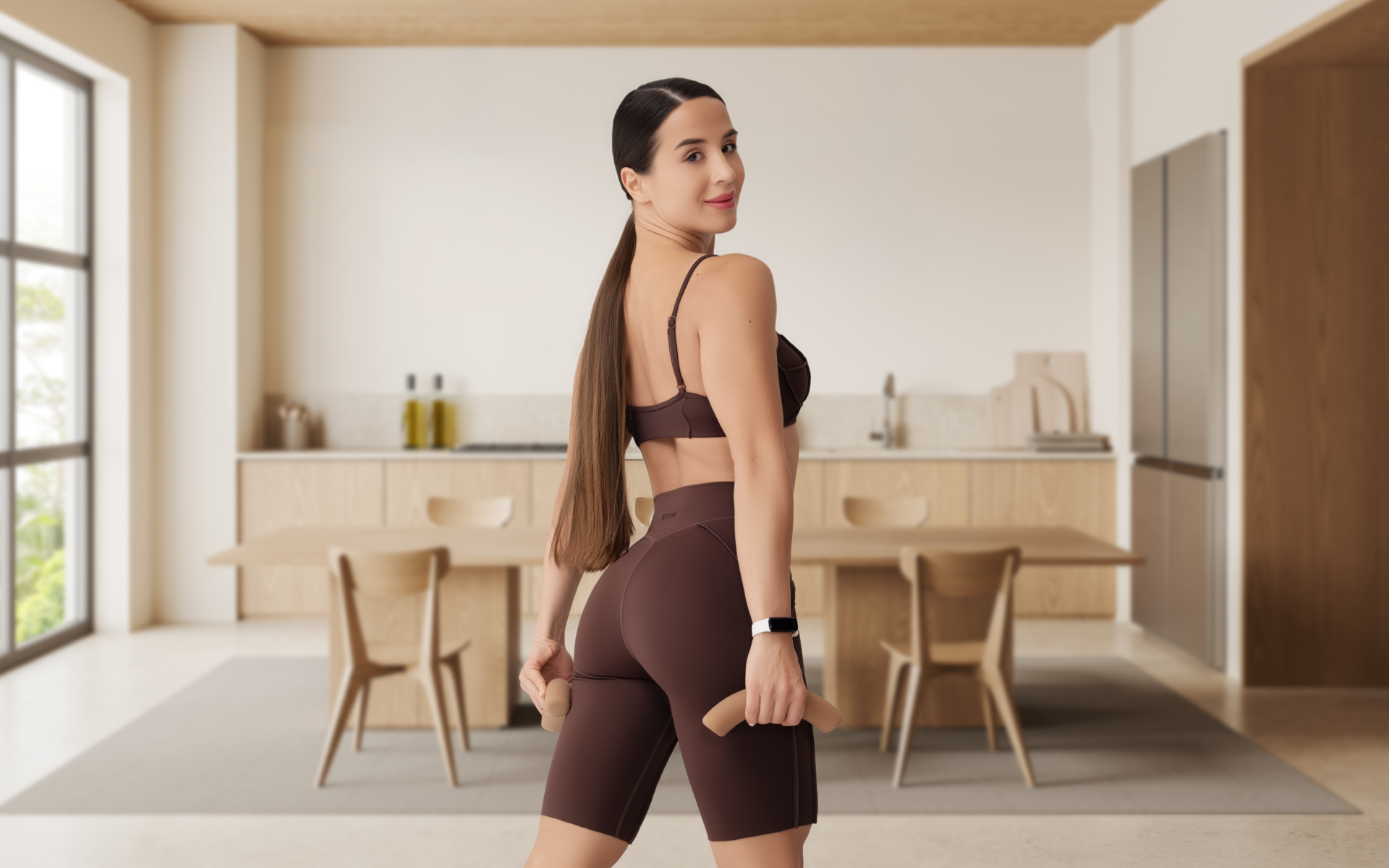 Woman in activewear holding dumbbells at home, illustrating lifting weights while fasting.