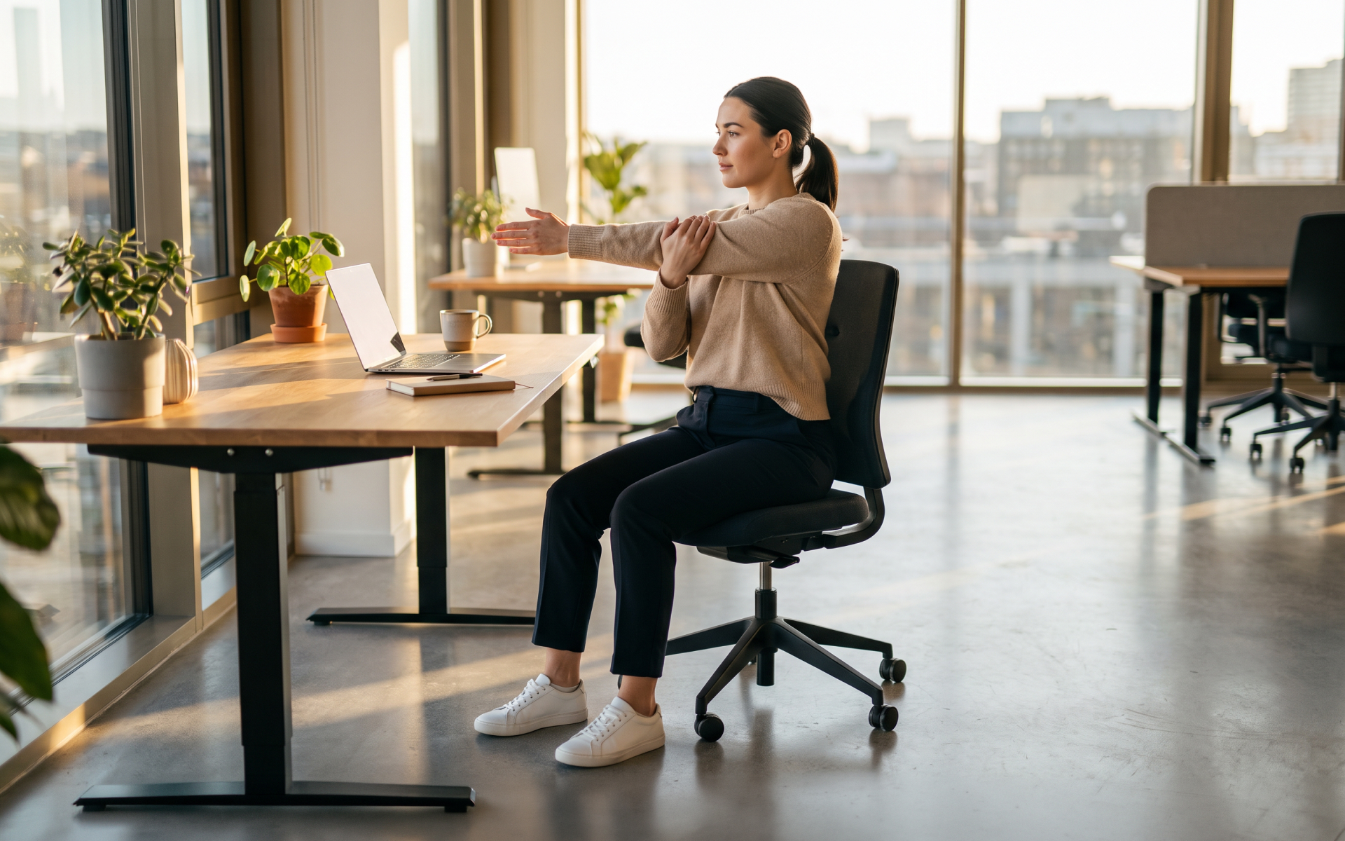 Woman performing chair exercises for office workers while seated at a desk in a bright modern office.