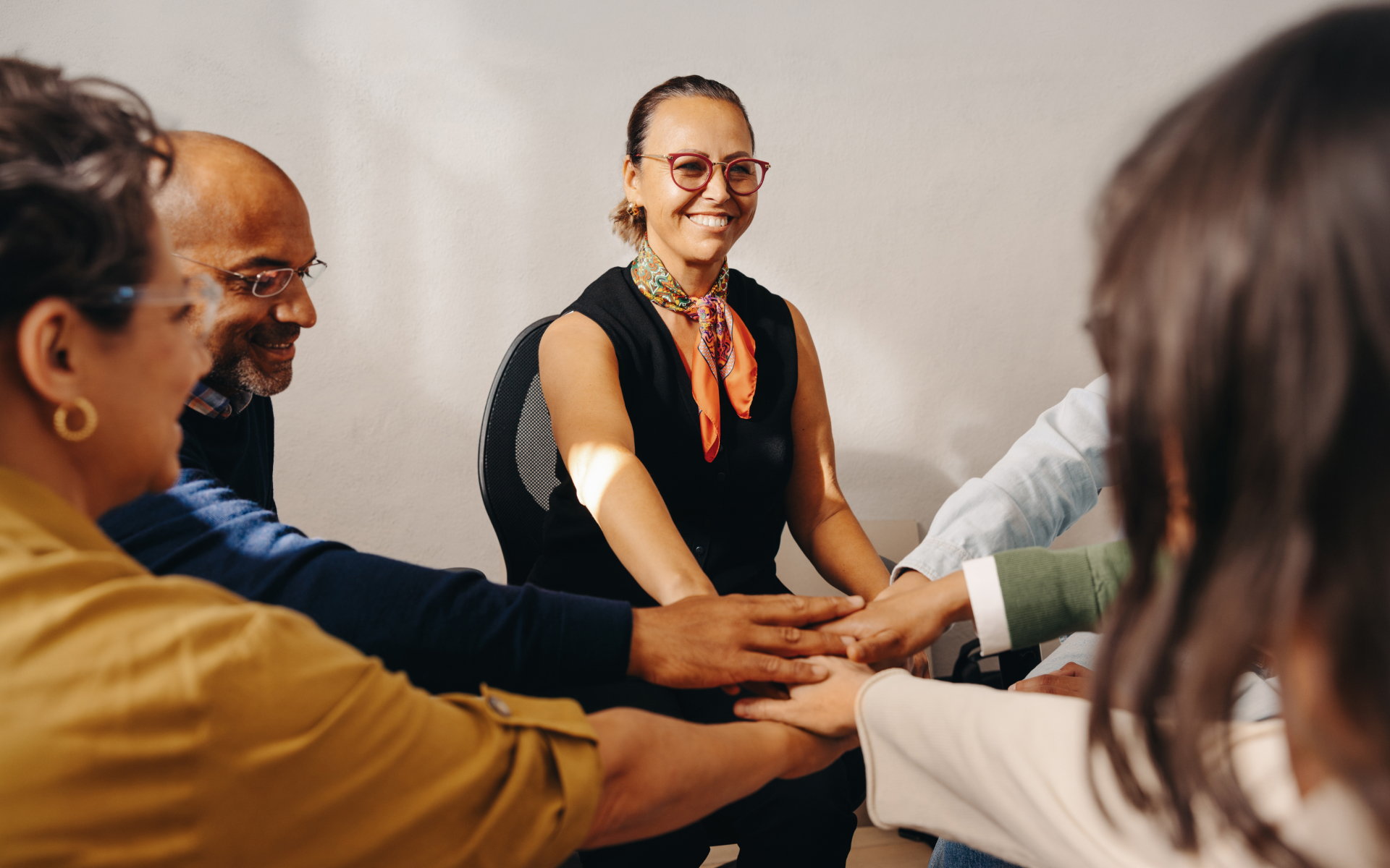 Employees joining hands during a team wellness activity, illustrating how gamified corporate wellness challenges improve participation and engagement.