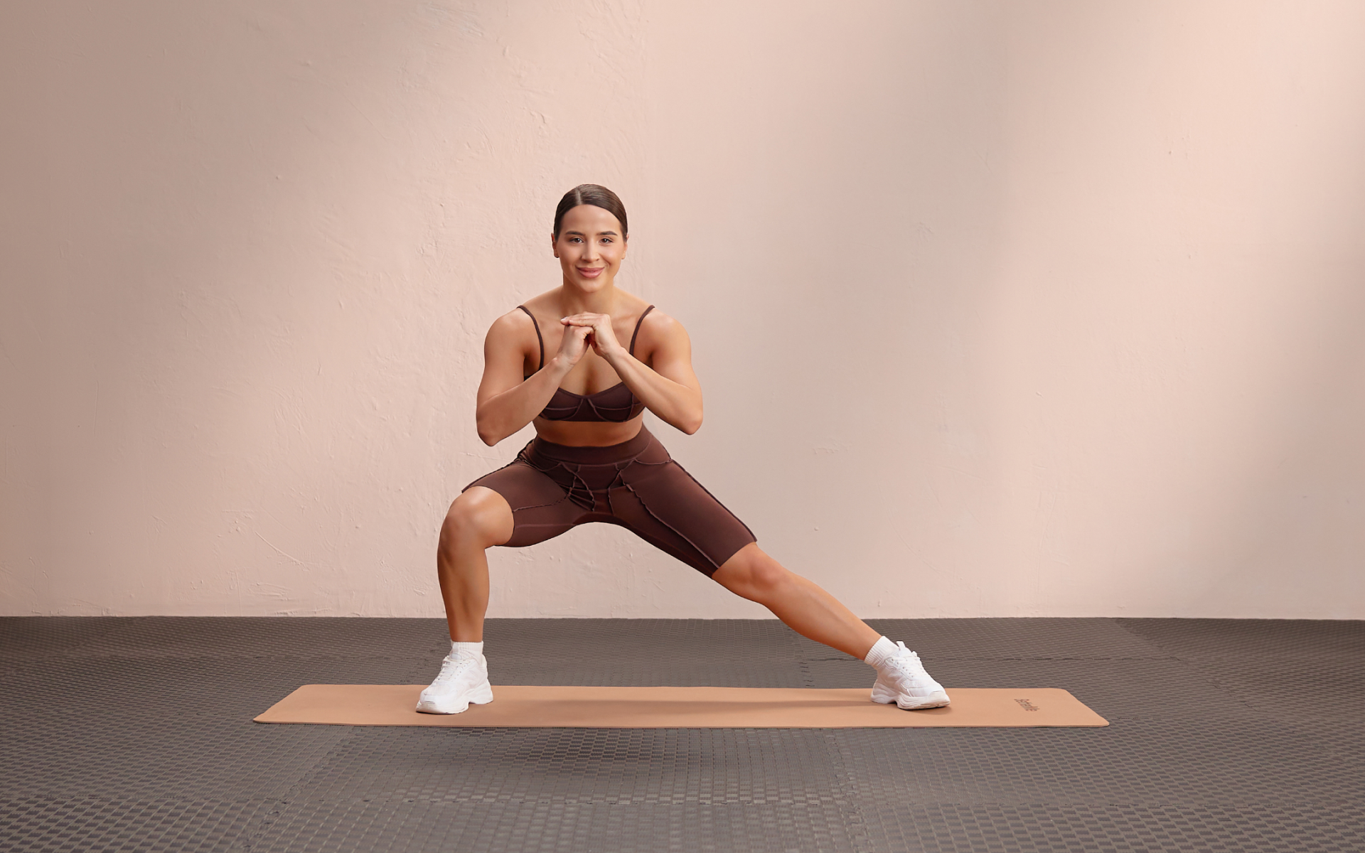 Woman performing a side squat on a mat for a squat workout plan.
